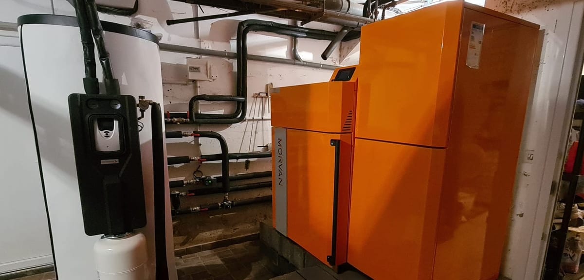 Chaudière à granulés Morvan orange installée en chaufferie aux côtés d'un ballon ECS par Hapînov