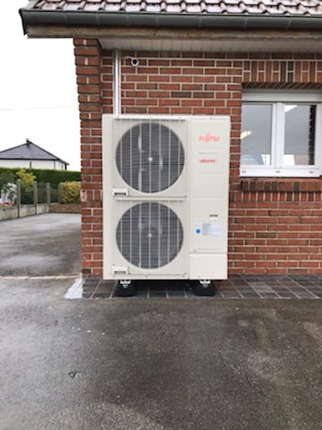 Pompe à chaleur Fujitsu Atlantic monobloc installée le long d'une façade en brique par Hapînov