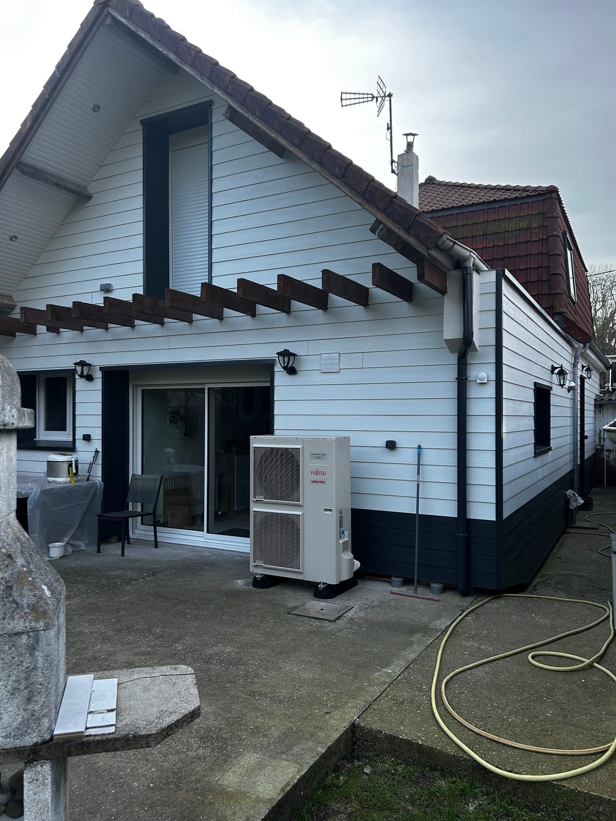 Pompe à chaleur Fujitsu Atlantic installée le long d'une maison avec bardage par Hapînov dans le Pas-de-Calais